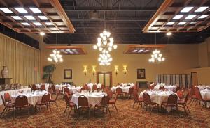 einen Bankettsaal mit weißen Tischen, Stühlen und Kronleuchtern in der Unterkunft Holiday Inn Blytheville, an IHG Hotel in Blytheville