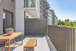 een patio met een houten tafel en banken op een balkon bij Cozy apartment with huge terrace in Vilnius