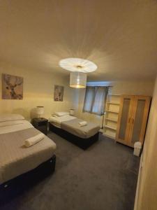 ein Hotelzimmer mit 2 Betten und einem Kronleuchter in der Unterkunft Modern 2BR Chester Flat in Chester