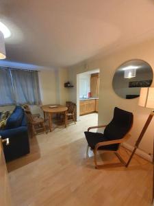 ein Wohnzimmer mit einem Sofa, einem Tisch und Stühlen in der Unterkunft Modern 2BR Chester Flat in Chester