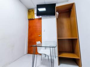 a small room with a glass table and a wooden door at SANTA VICTORIA HOUSE in Chiclayo