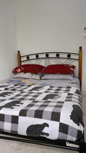 een slaapkamer met een bed met een zwart-witte quilt bij One Mek Homestay in Bachok