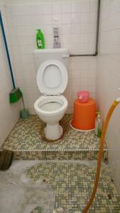 een badkamer met een toilet in een betegelde kamer bij One Mek Homestay in Bachok