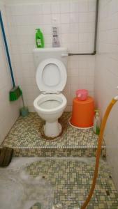 a bathroom with a toilet in a tiled room at One Mek Homestay in Bachok +26 photos