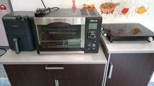 a microwave oven sitting on top of a kitchen counter at One Mek Homestay in Bachok