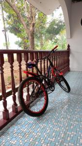 een fiets staat geparkeerd op een leuning op een veranda bij One Mek Homestay in Bachok