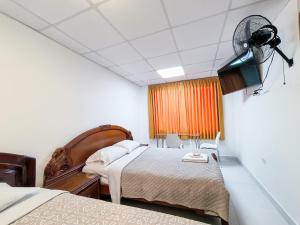 Habitación de hotel con 2 camas y ventilador en SANTA VICTORIA HOUSE, en Chiclayo