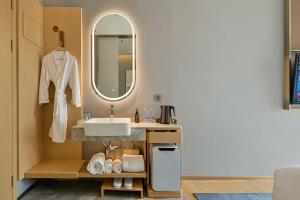 W łazience znajduje się umywalka i lustro. w obiekcie Lux Cabins Hotel Shenzhen w mieście Shenzhen