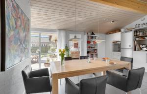 uma cozinha e sala de jantar com uma mesa de madeira e cadeiras em Amazing Home In Kge With Kitchen em Koege