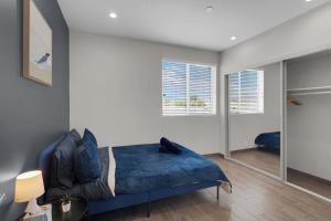 a bedroom with a blue bed and a mirror at Luxury Three-Bedroom Condo in Los Angeles