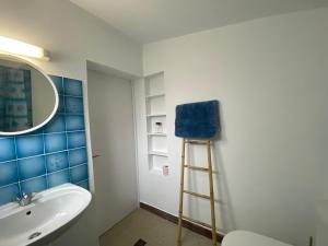 ein Badezimmer mit einem Waschbecken, einem Spiegel und einer Leiter in der Unterkunft Maison Saint-Brevin-les-Pins, 1 pièce, 2 personnes - FR-1-364-158 in Saint-Brevin-les-Pins