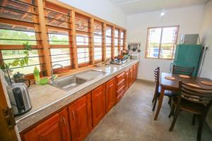 a kitchen with wooden cabinets and a sink and a table at Donkey clinic and education center in Mannar