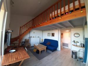 uma sala de estar com um sofá azul e uma escada em Appartement Seignosse, 2 pièces, 4 personnes - FR-1-239-999 em Seignosse