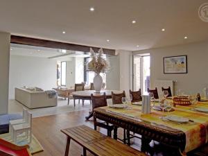 uma sala de jantar e sala de estar com mesa e cadeiras em Gîte Saint-Symphorien-de-Lay, 5 pièces, 12 personnes - FR-1-496-312 em Saint-Symphorien-de-Lay