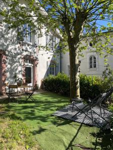 維也納的住宿－Charmante maison à Vienne avec jardin, prox Lyon，房屋前的院子,有椅子和一棵树