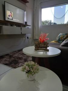 a living room with two tables and a tv at Apartamento super confortável in Campina Grande