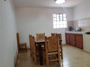 a kitchen with a table and chairs in a room at Hotel Cabañas Chalamu in Pátzcuaro