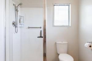 a bathroom with a toilet and a shower at Harbourside Cove in Raglan +21 photos