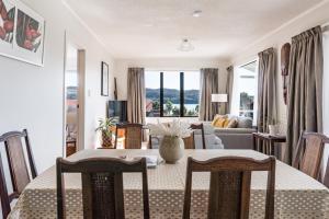 a living room with a table and chairs and a living room at Harbourside Cove, Water Views, Cosy, Peaceful in Raglan