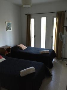 a hotel room with two beds with towels on them at Casa de Familia Jiro in Punta Del Diablo