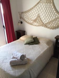 1 dormitorio con 1 cama con toallas en Casa de Familia Jiro, en Punta del Diablo