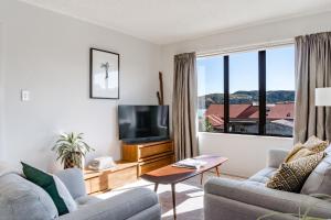 a living room with a tv and a couch at Harbourside Cove, Water Views, Cosy, Peaceful in Raglan