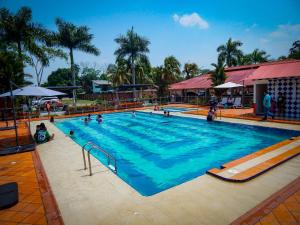 a large swimming pool with people in it at Hotel campestre las palmas in Villavicencio