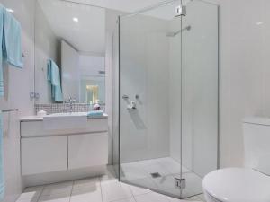 a bathroom with a shower and a toilet and a sink at Luxury Apartments at Bells Blvd in Kingscliff