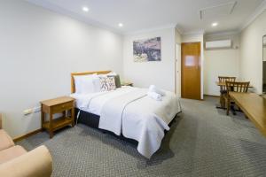 um quarto de hotel com uma cama grande e uma mesa em Roydons Motor Inn em Tamworth