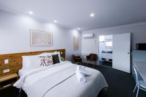 タムワースにあるRoydons Motor Innのベッドとデスクが備わるホテルルームです。