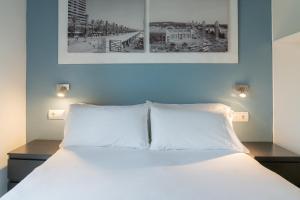 a bed with two white pillows in a room at Stay U-nique Apartments Nació in Barcelona