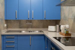 a kitchen with blue cabinets and a sink at Stay U-nique Apartments Nació in Barcelona +81 photos
