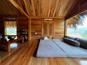 ein Schlafzimmer mit einem großen Bett in einem Zimmer mit Holzwänden in der Unterkunft Na Tuệ An-Homestay 81 Võ Văn Kiệt in Tuyên Quang