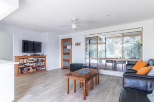 a living room with a couch and a table at Waterfront on Plover in Sussex inlet