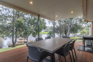 a table and chairs on a deck with a view of the water at Waterfront on Plover in Sussex inlet