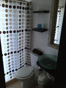 a bathroom with a toilet and a shower curtain at Casa de Familia Jiro in Punta Del Diablo