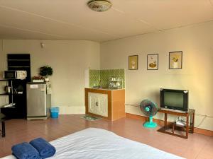 een woonkamer met een bed en een televisie bij Condo popular T8 fl.8.2 in Thung Si Kan