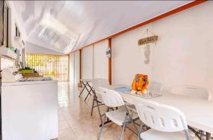 a dining room with white chairs and a table at Casa en Playa Tambor - A 5 minutos de la playa in Tambor