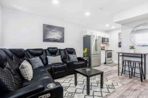 a living room with a black leather couch and a kitchen at Mazor Luxury Two Bedroom Vacation Home in Fort Lauderdale