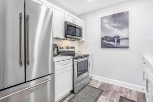 a kitchen with a stainless steel refrigerator and white cabinets at Mazor Luxury Two Bedroom Vacation Home in Fort Lauderdale +15 photos