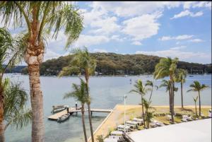 a view of a body of water with palm trees at Pasadena Sydney in Church Point