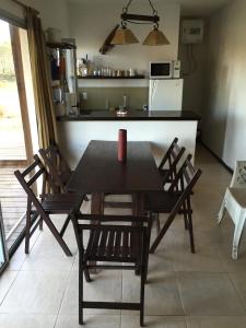 una mesa y sillas en una cocina con encimera en Casa de Familia Jiro en Punta del Diablo