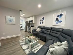 フォート・ローダーデールにあるRachaels Upscale 3 Bedrooms Luxury Homeのリビングルーム(黒い革張りのソファ、テーブル付)