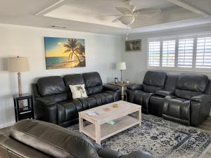 a living room with black leather couches and a coffee table at Island House Beach Resort 40B in Siesta Key