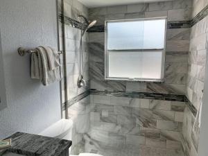 a bathroom with a shower with a window and a toilet at Island House Beach Resort 40B in Siesta Key