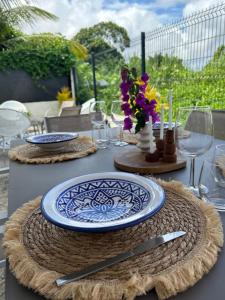 a table with plates and glasses and flowers on it at Maison La Caféière in Saint-Claude