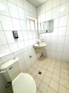 un bagno bianco con un water e un lavandino di Xingang Homestay a Xingang