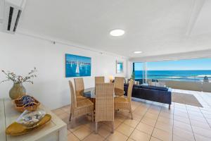 a dining room with a table and a view of the ocean at Zenith Ocean Front Apartments in Gold Coast