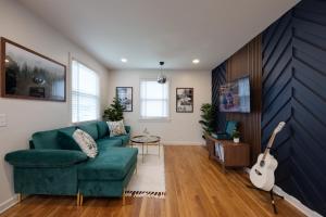 a living room with a green couch and a guitar at Taylor Swift Eras Inspired Home-10 min to Broadway in Nashville