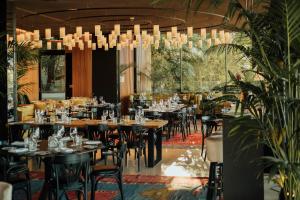 um restaurante com mesas e cadeiras sob um lustre em Memmo Príncipe Real - Design Hotels em Lisboa